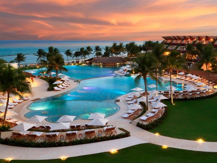 an aerial view of a resort pool at sunset