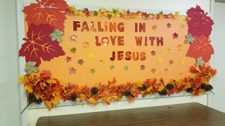 a bulletin board that says falling in love with jesus surrounded by leaves and acorns