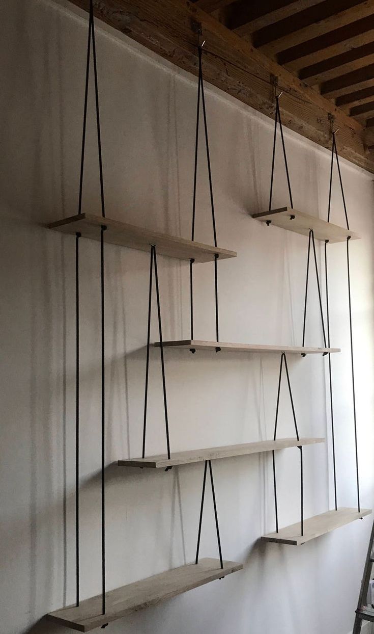 several shelves are hanging on the wall with ladders