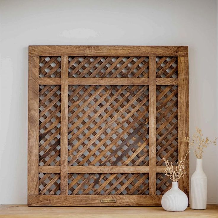 a wooden frame sitting on top of a table next to a vase