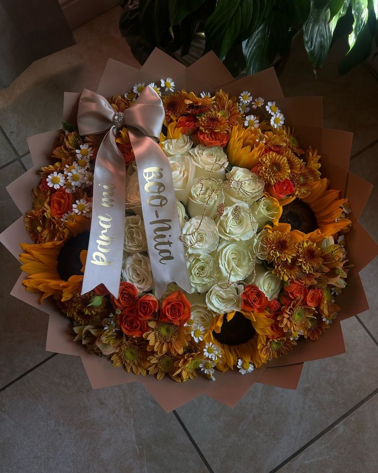 a bunch of flowers that are sitting in a bouquet on the floor next to a potted plant