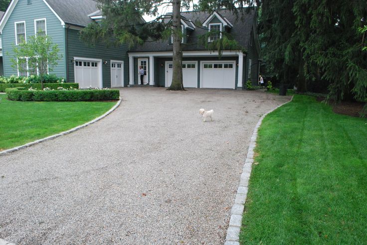 a driveway leading to a large house with two garages