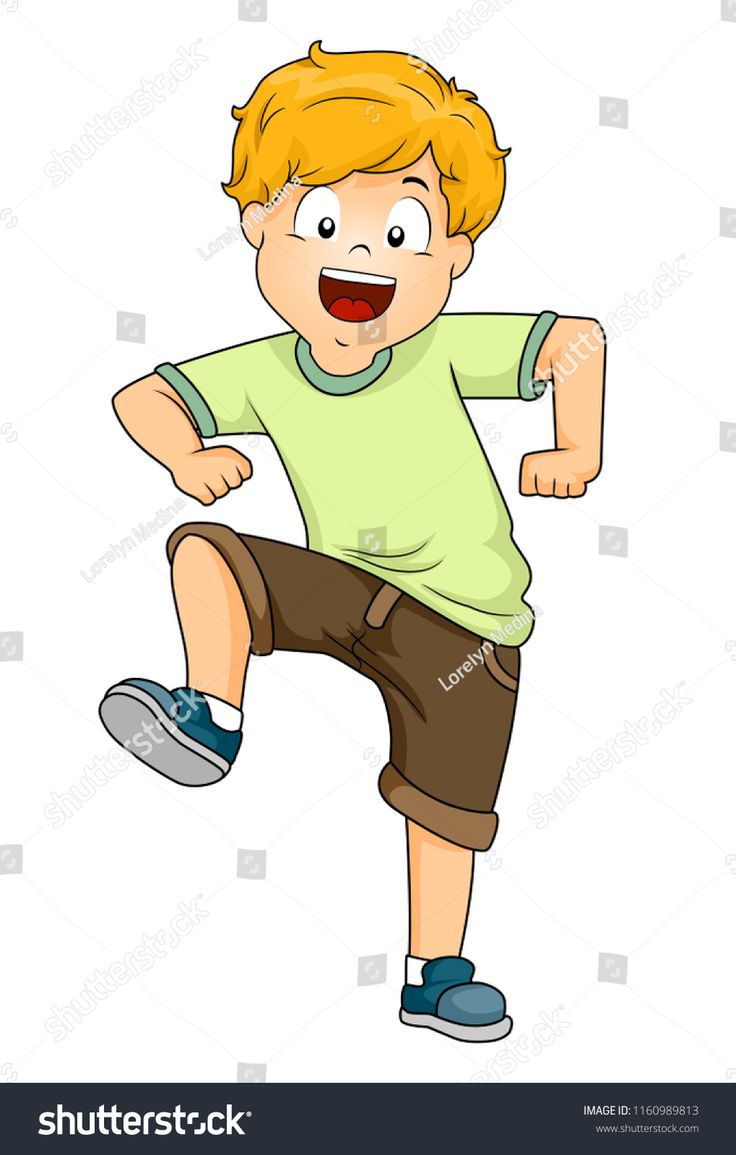 a young boy is dancing with his hands in the air while wearing shorts and a green shirt