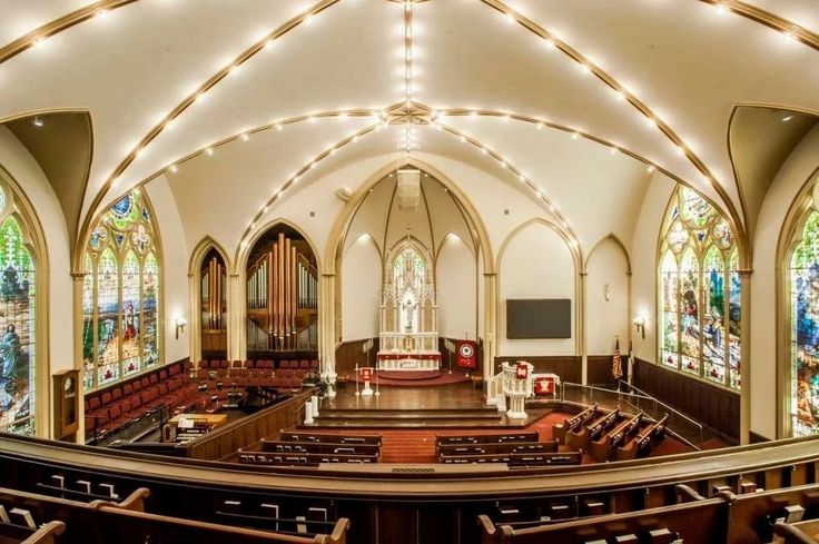 the interior of a church with stained glass windows and pews in rows on both sides