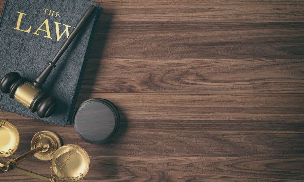 a law book, gavel and other items on a wooden table