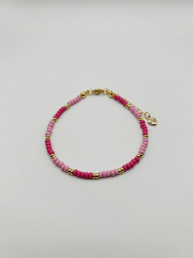 Dainty pink glass seed bead bracelet with light and dark pink and gold-filled accents. Perfect for stacking or on its own!  Adjustable 7-8". Pink Heishi Beads Jewelry With Spacer Beads, Adjustable Beaded Pink Gold Bracelets, Pink Round Beaded Bracelets For Friendship, Pink Tiny Beads Friendship Bracelets As Gift, Pink Bracelets With Colorful Beads For Friendship, Adjustable Pink Beaded Necklace For Friendship, Pink Tiny Beads Friendship Bracelet As Gift, Pink Dainty Friendship Bracelets For Beach, Dainty Pink Jewelry With Colorful Beads