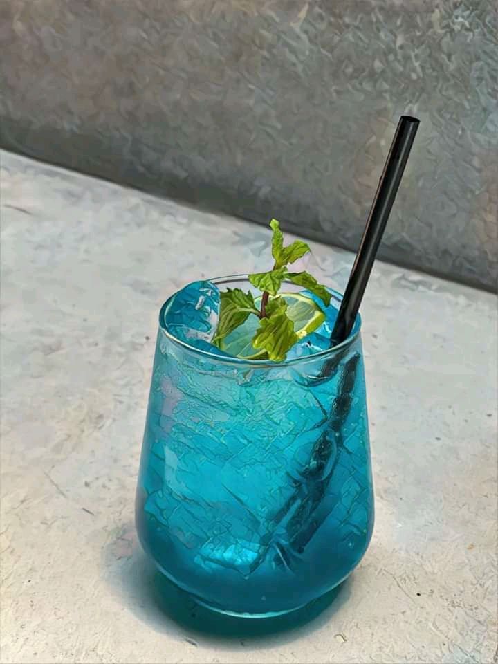 a blue drink with a straw in it