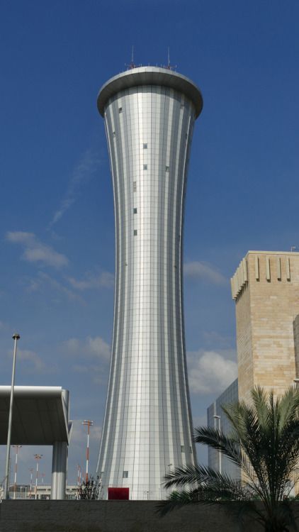 a tall building with a very large tower next to it's entrance and palm trees in the foreground