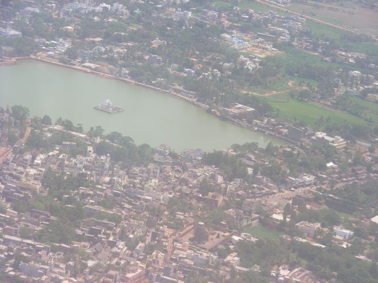 an aerial view of a large body of water surrounded by buildings and trees in the foreground