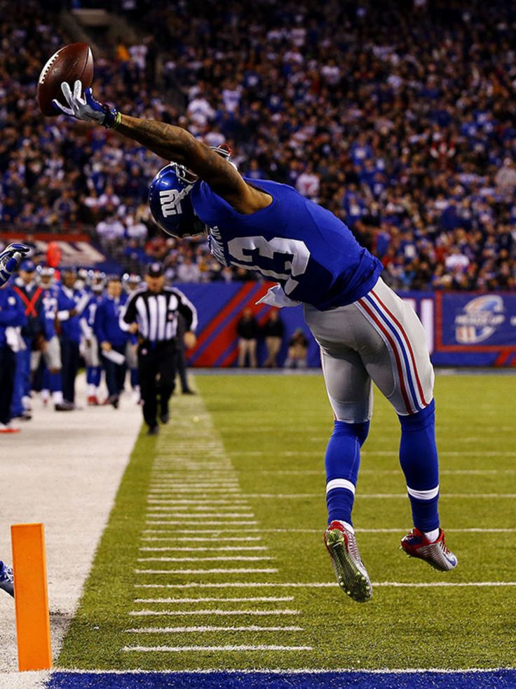 an autographed photograph of a football player leaping into the air to catch a ball