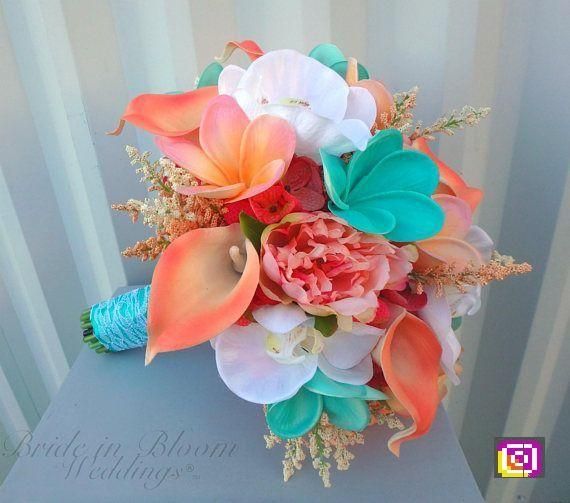 a bridal bouquet with orange, pink and white flowers on top of a blue box