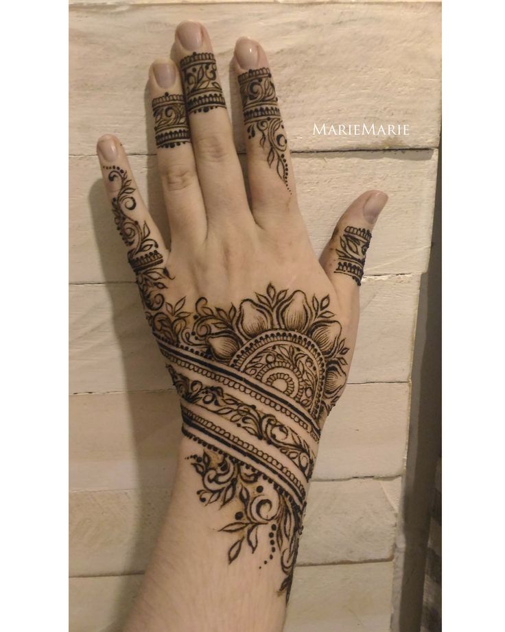 a woman's hand with henna tattoos on it