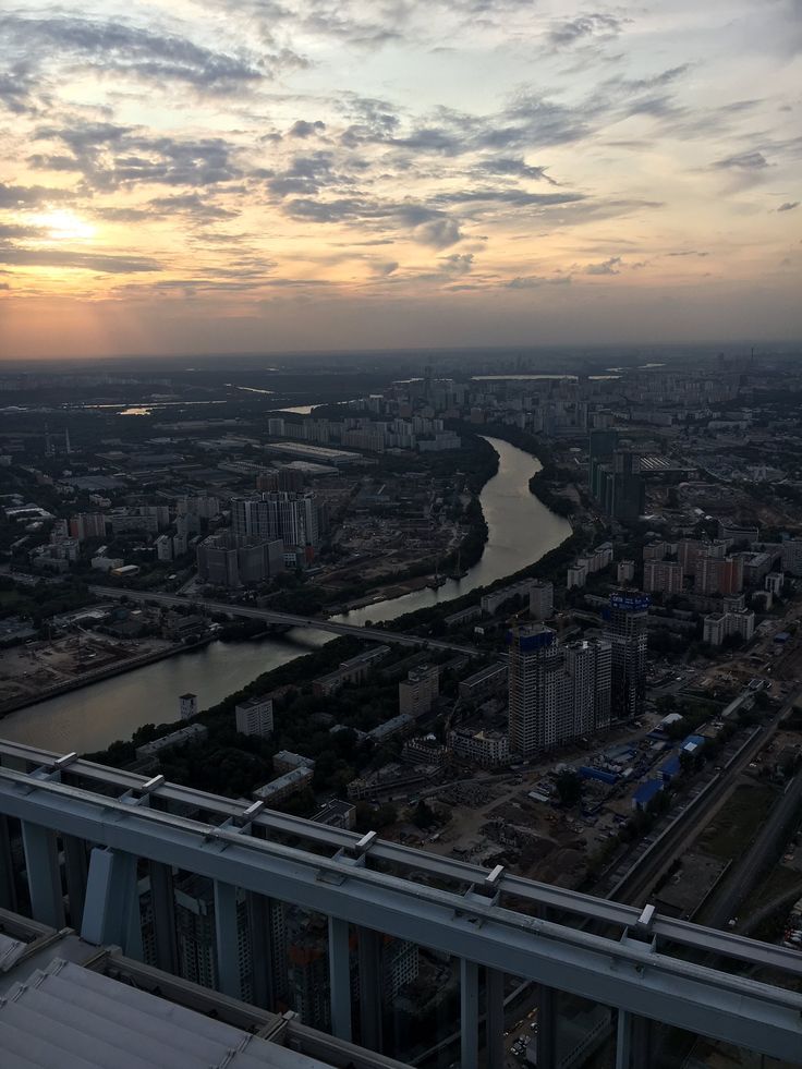 an aerial view of a river and city at sunset or dawn from the top of a building