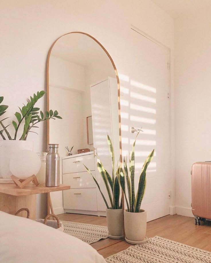 a living room filled with furniture and a large mirror on the wall next to a bed