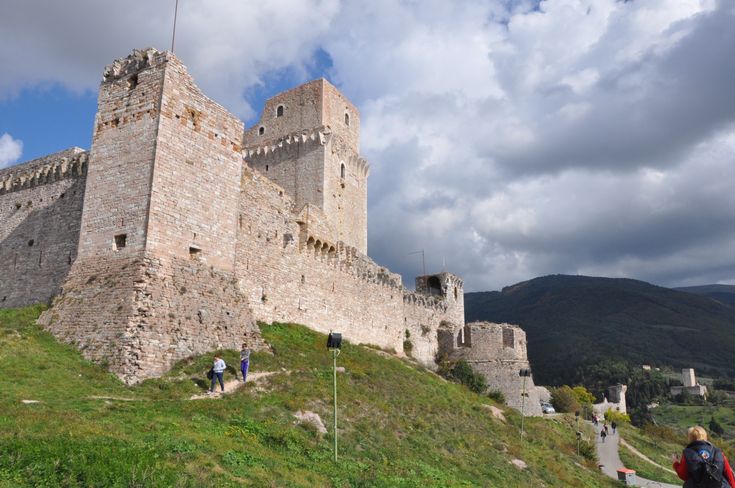 people are walking up the side of a castle