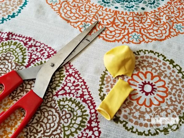 two pairs of scissors sitting on top of a table cloth with yellow and red handles