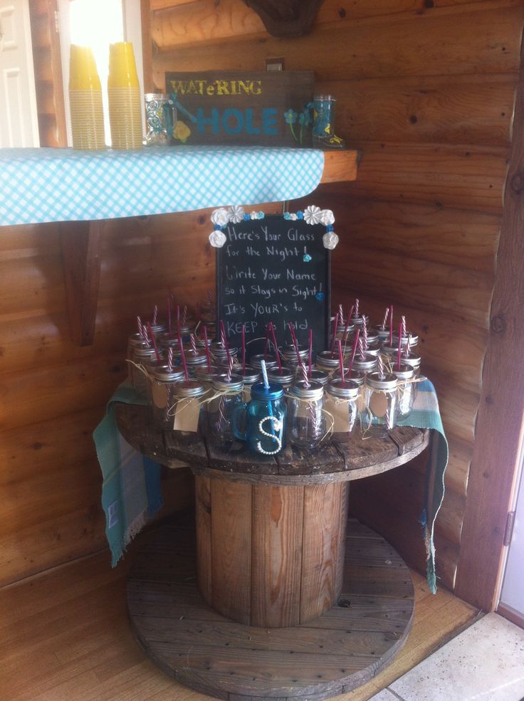 a wooden table topped with jars filled with drinks