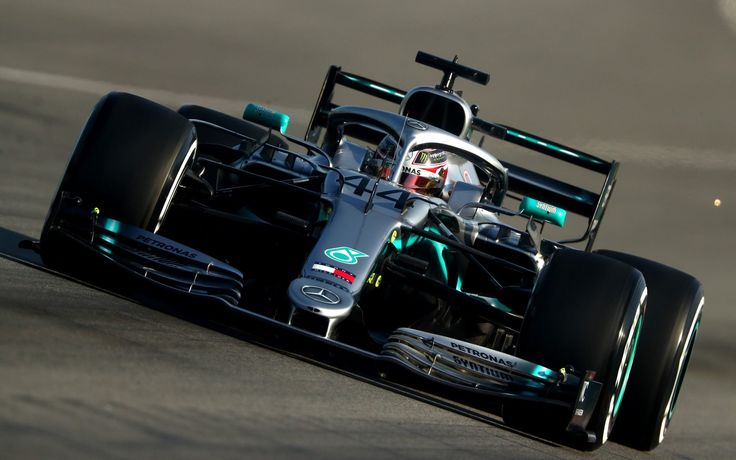 a man driving a racing car on top of a race track with lights on it