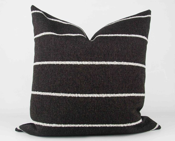 a black and white striped pillow sitting on top of a table