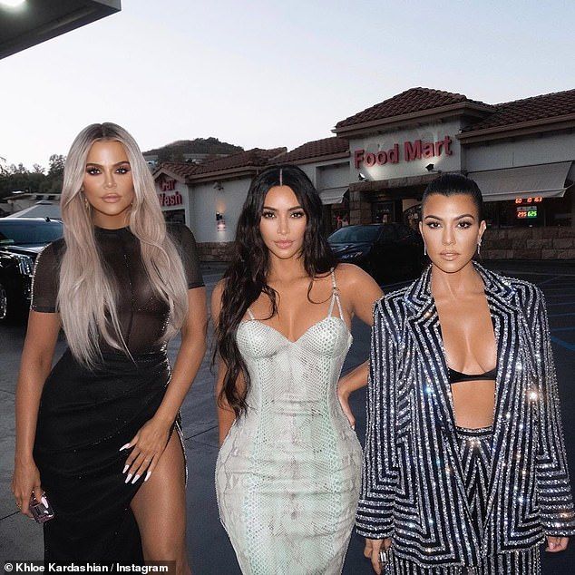 three women standing next to each other in front of a store with their dresses on