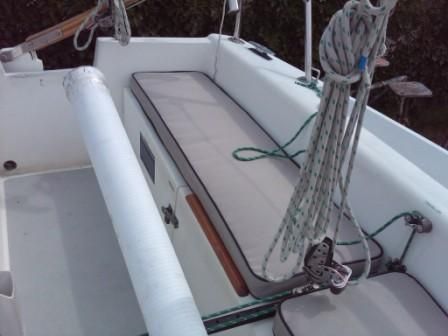 the back end of a boat with two seats and ropes hanging from it's side