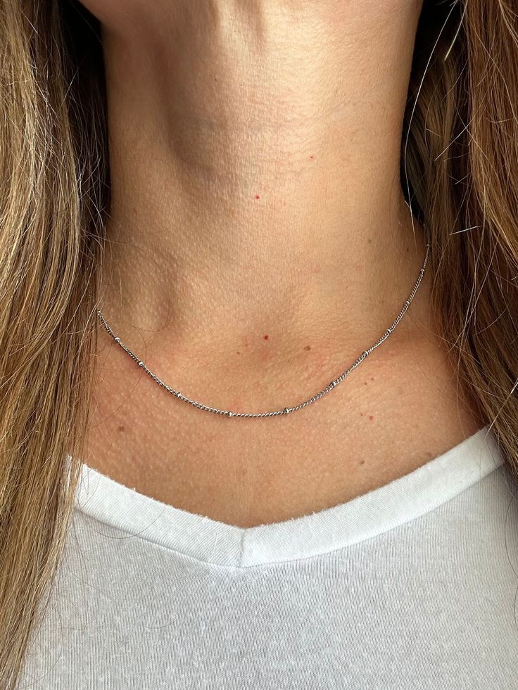 Our favorite layering chain necklace is the Delilah Beaded Satellite chain.    This delicate Stainless Steel or 14K Gold Plated Stainless Steel chain necklace sits close to the neck and features tiny 2mm beads every 2cm.    Wear it on its own for a simple and chic look or pair it with your other favorite necklaces for the ultimate layered look.   Bring instant dimension and flair to your stack with the Delilah Beaded Satellite chain.  Safe for sensitive skin & shower safe. ITEM DESCRIPTION ❤ Choker Necklace ❤ Color:  available in Silver or 14K Yellow Gold ❤ Length: 15 in + 2 in extender ❤ Material: Stainless Steel or 14K Gold Plated Stainless Steel ❤ Sold Individually  ❤ Free Shipping  P R O M O T I O N ✦ 20% Discount is applied for purchases of 2 or more products. Coupon Code: 20FORYOU ✦ 2mm Beads, Choker Gold, Stainless Steel Chain Necklace, Necklace Layering, Gold Bead Necklace, Necklace Beaded, Layering Necklace, Keep Jewelry, Chain Choker