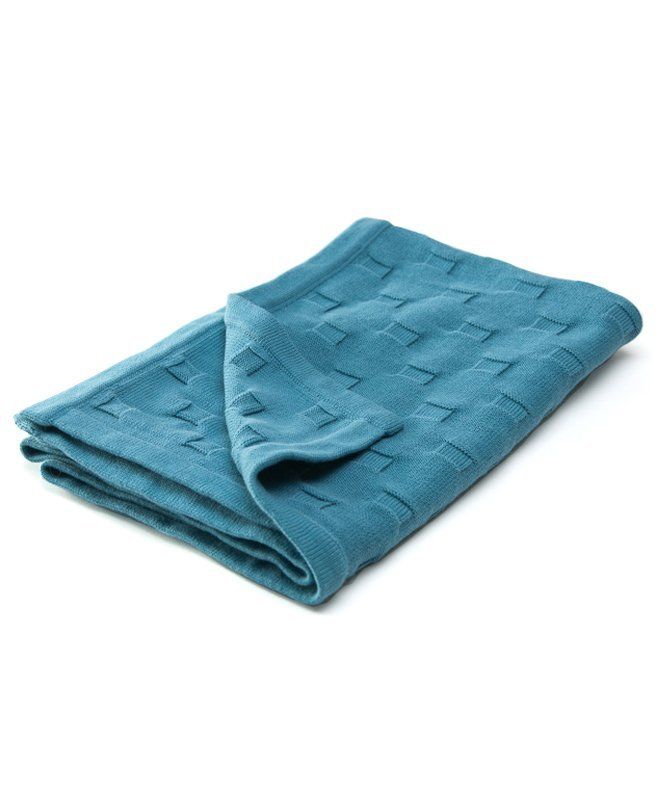 a blue blanket folded on top of a white surface