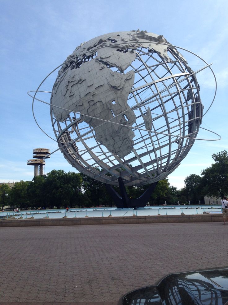 a car parked in front of a large metal globe