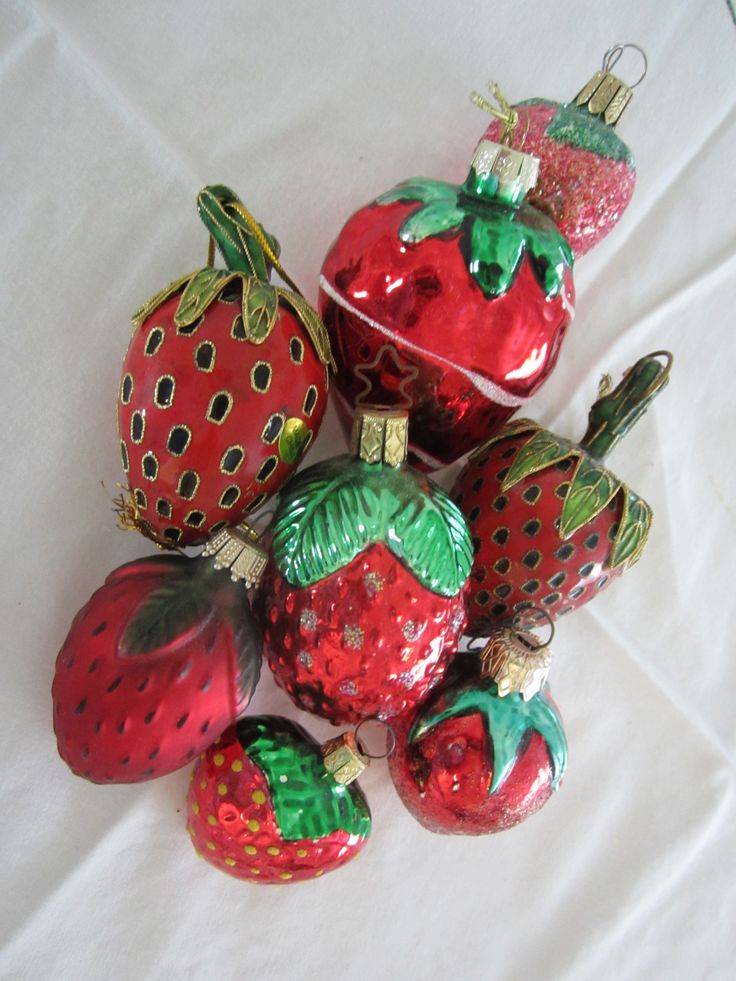 a group of red and green ornaments sitting on top of a white cloth covered table