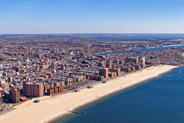 an aerial view of a city next to the ocean