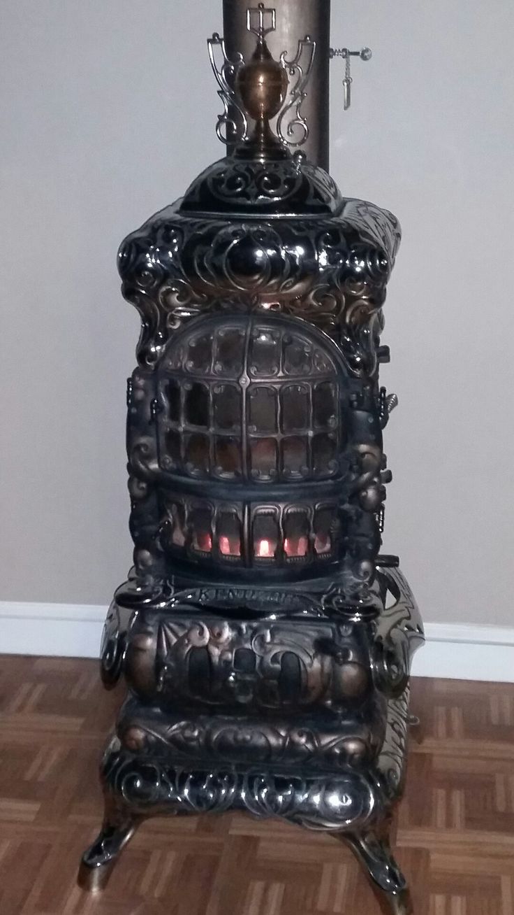 an old fashioned stove sitting on top of a hard wood floor