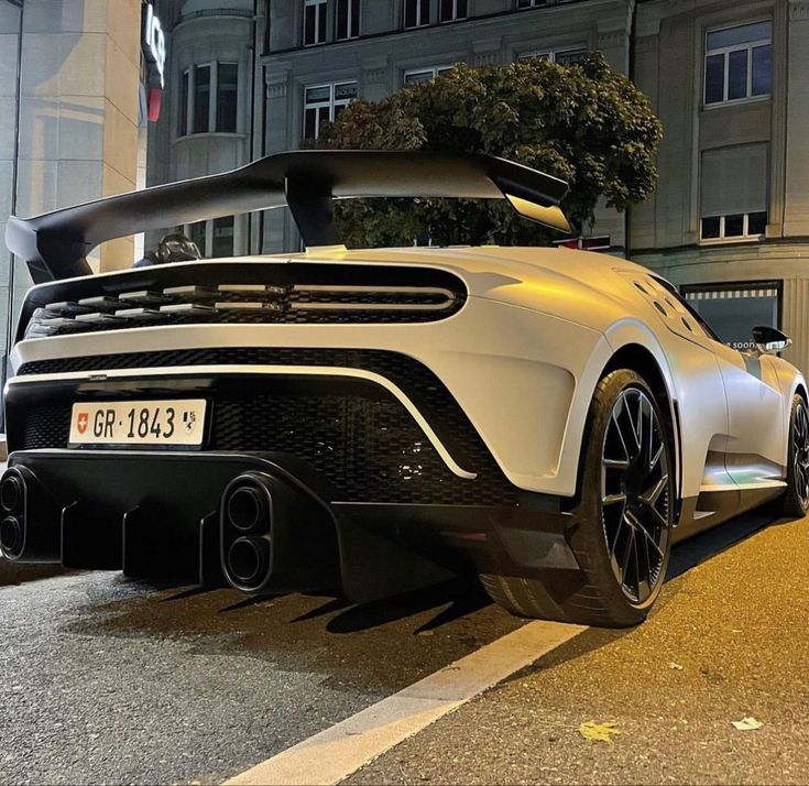 a white sports car parked in front of a building