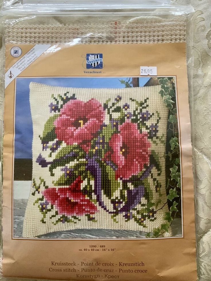 the cross stitch pattern is in plastic bag and has pink flowers on it with green leaves