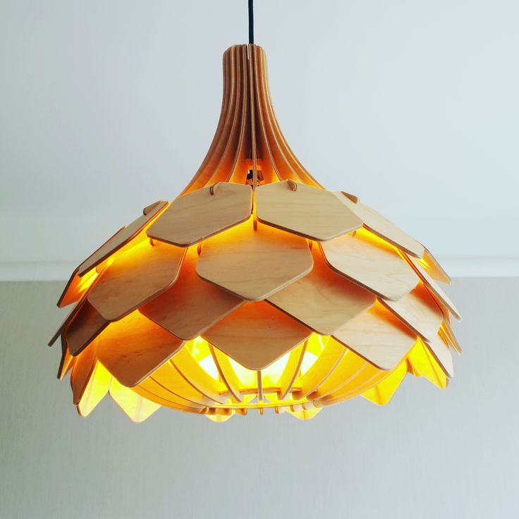 a wooden light fixture hanging from the ceiling with yellow lights on it's sides