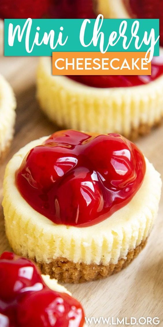 mini cherry cheesecakes on a cutting board with cherries in the foreground