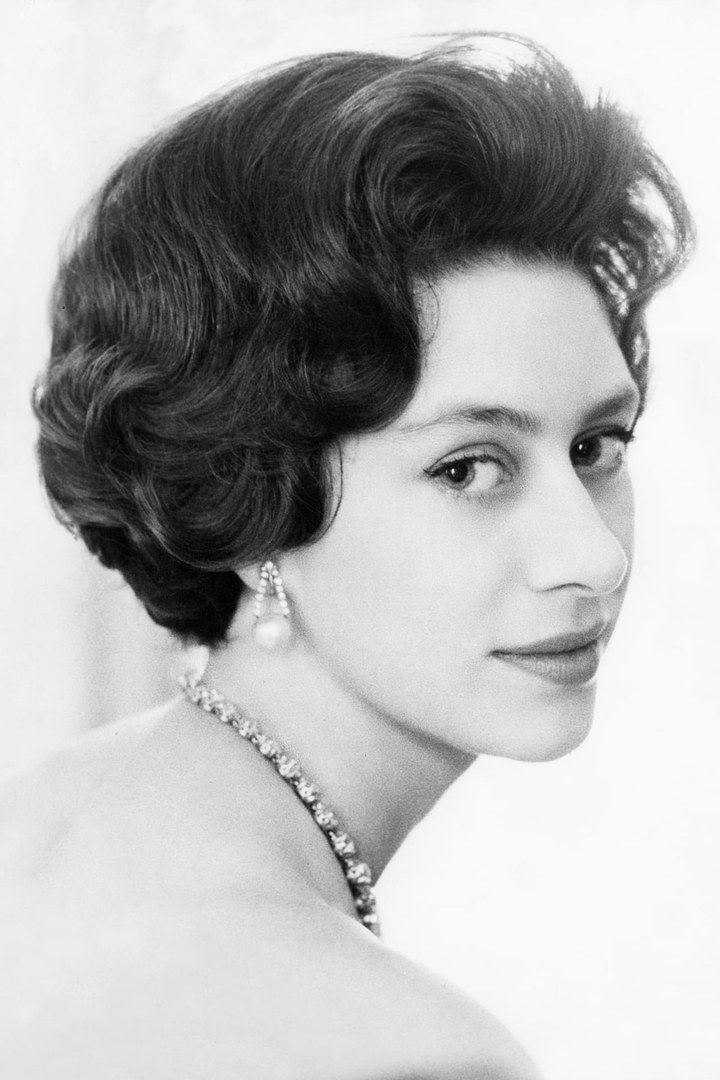 an old black and white photo of a woman wearing a tiara with pearls on her head