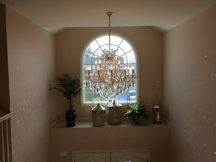 a chandelier hanging from the side of a window