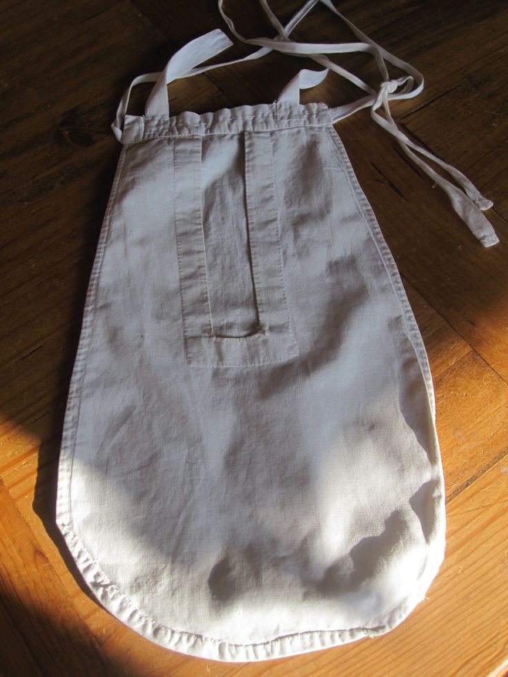 a white bag sitting on top of a wooden floor next to a pair of scissors