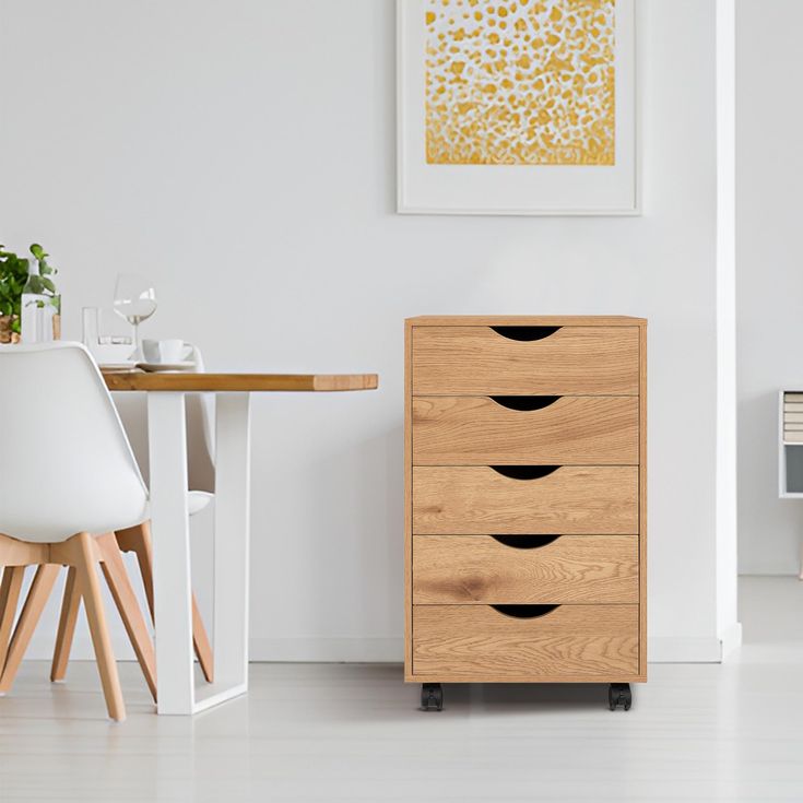 a wooden dresser sitting next to a white chair