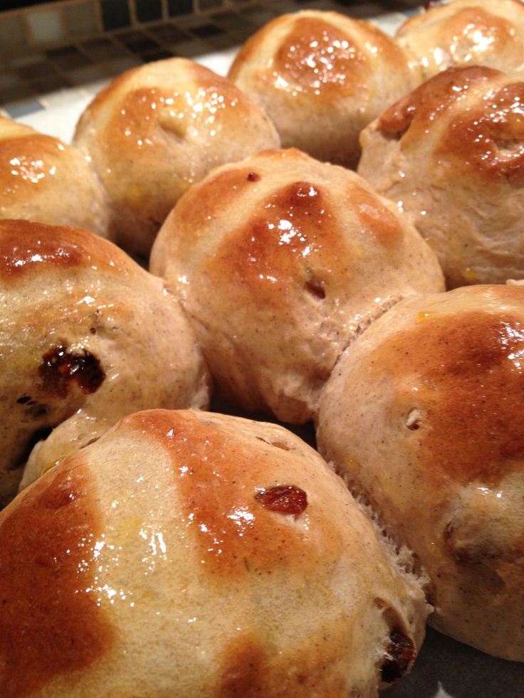 freshly baked hot cross buns on a baking sheet