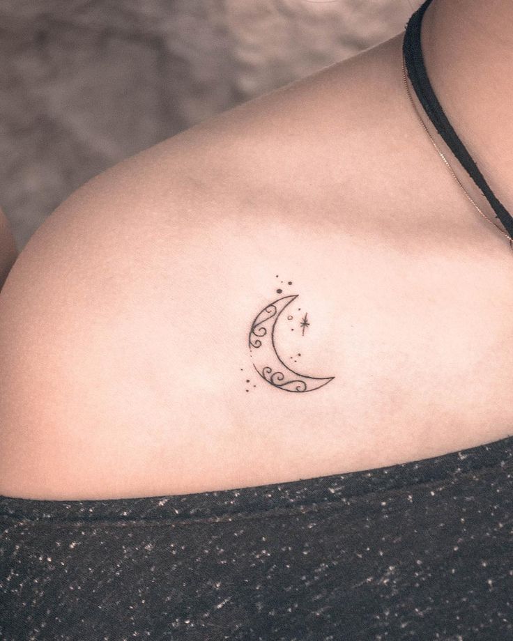 a woman's stomach with a crescent tattoo on her left side breast and the moon behind it