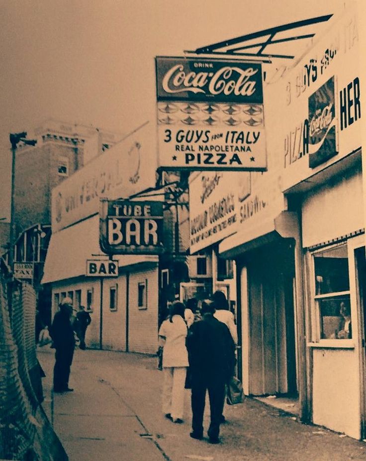 an old photo of people walking down the street