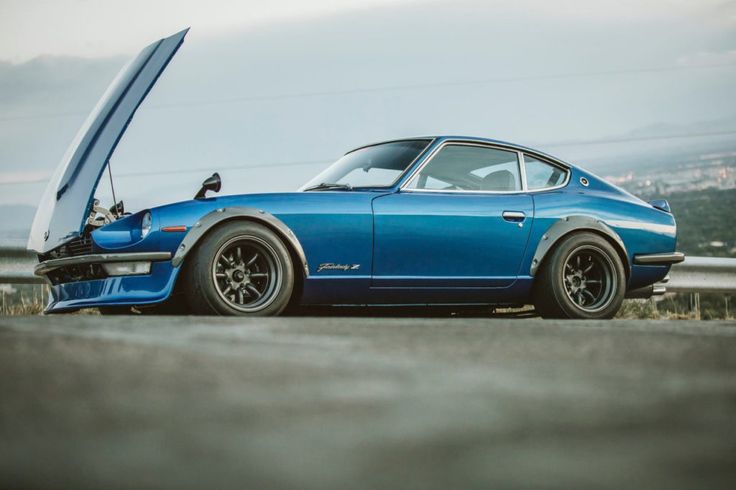 a blue sports car with its hood open