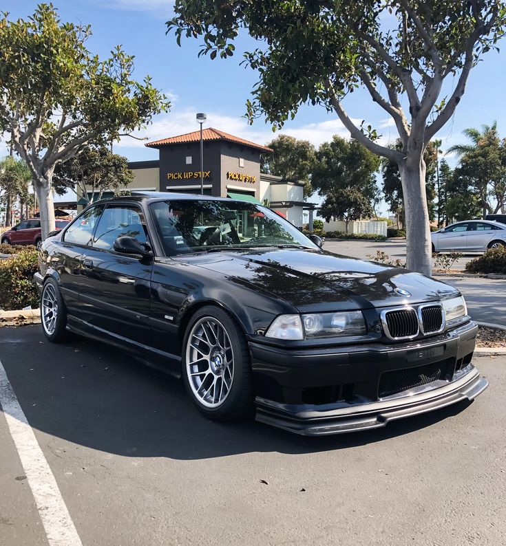 a black bmw is parked in the parking lot