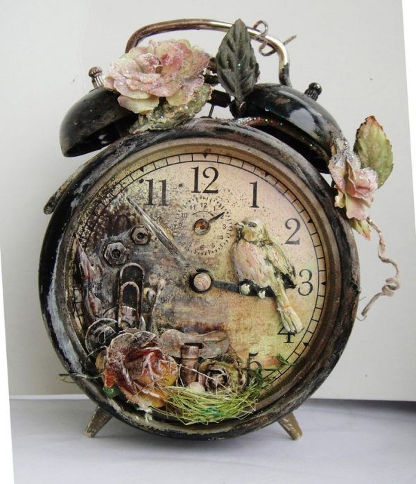 an old clock with flowers and birds on it's face is sitting in front of a white wall