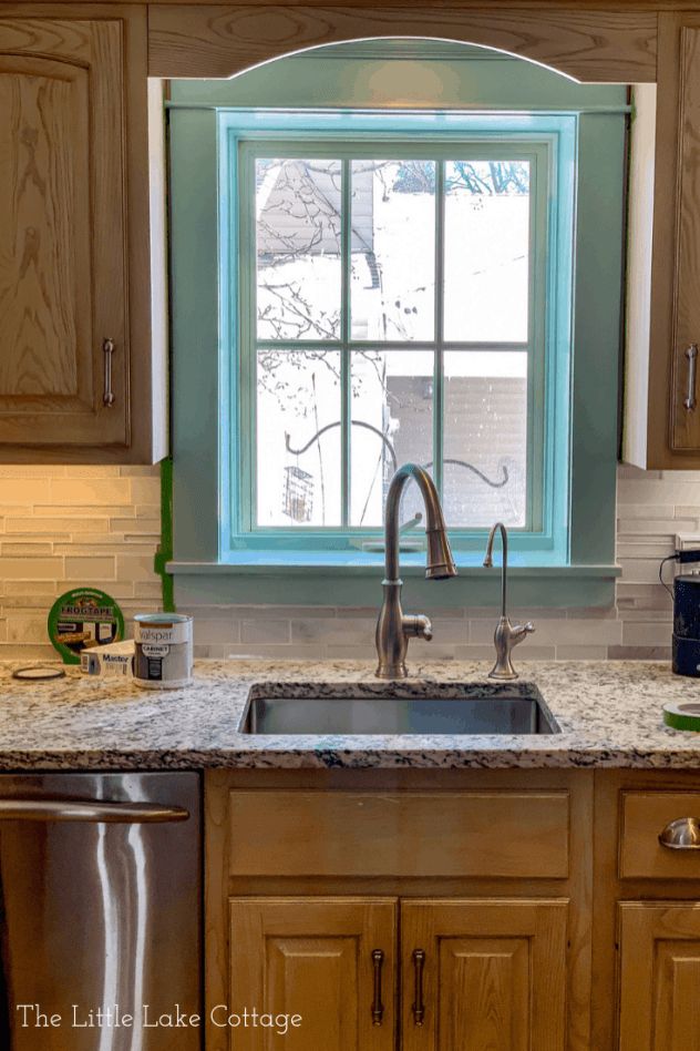 a kitchen with a sink, dishwasher and window in the wall above it