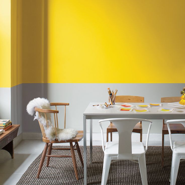 a dining room with yellow walls and white chairs