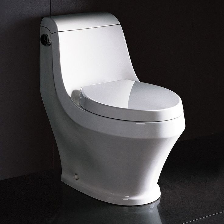 a white toilet sitting in a bathroom next to a black tiled wall with the lid up