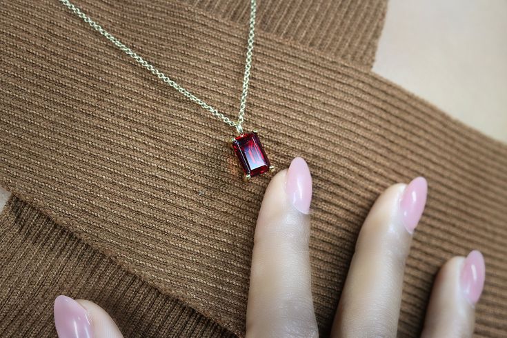 "Fall in love with the allure and elegance of this red stone necklace flaunting a Garnet pendant. This gemstone jewelry piece is a stunning piece to add to your ensemble. A classic Garnet necklace to add to your collection. ♥ Gemstone Type - Garnet (Lab Created) ♥ Gemstone Size - 7x11mm ♥ Gemstone Cut - Rectangle ♥ Metal Type (Main Photo) - 14k Gold Filled - Other options available in the drop down menu ♥ Length (Model Photo) - 45cm/18\" - Available from 14\" to 24\" (no additional cost) ❏ Why B