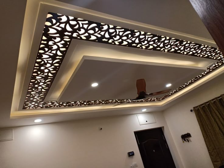 the ceiling in this room is decorated with intricate patterns and lights, along with a fan